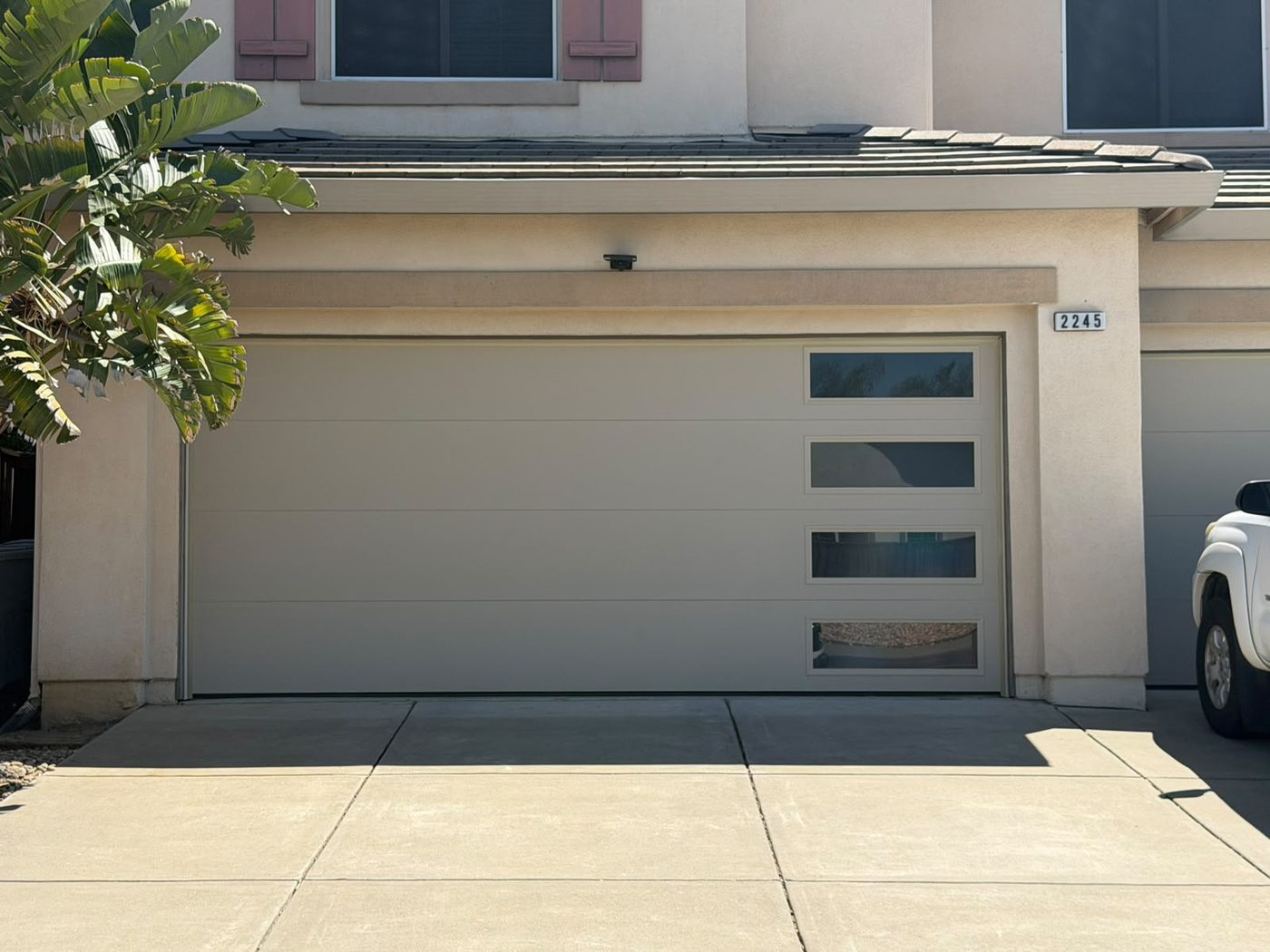 Sleek flush-panel garage door with a vertical column of windows