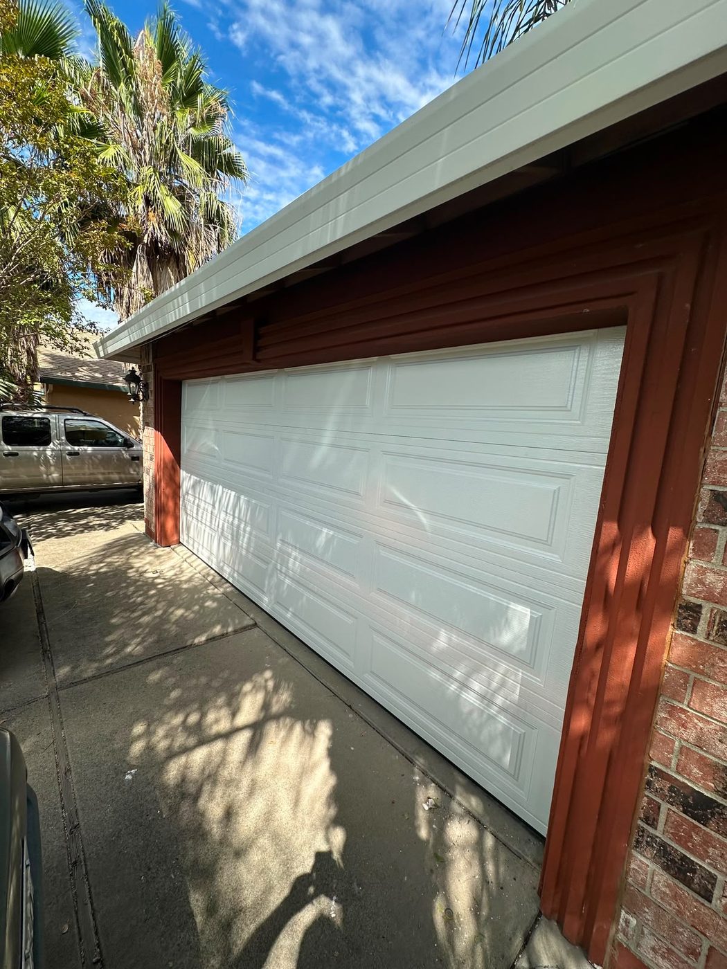 Classic white raised-panel garage door on a brick home